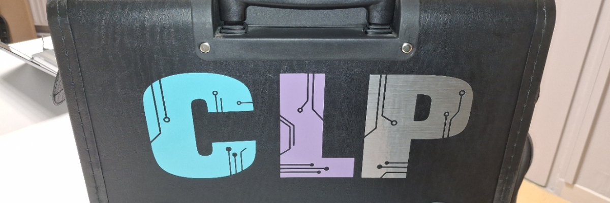 Valise noire avec les lettres "CLIP" et des circuits imprimés, sur un comptoir.