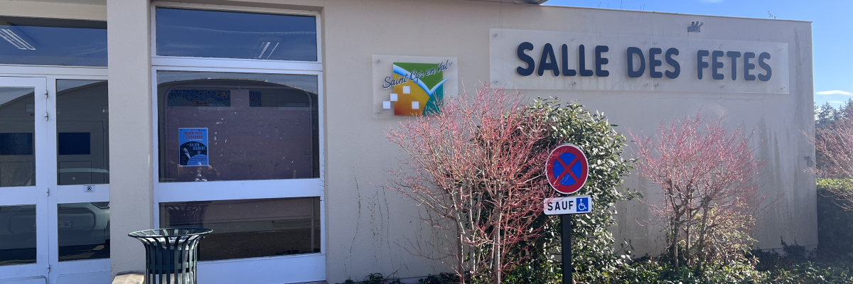 "Salle des fêtes avec porte, fenêtre, affiches, buisson et panneau de stationnement interdit."