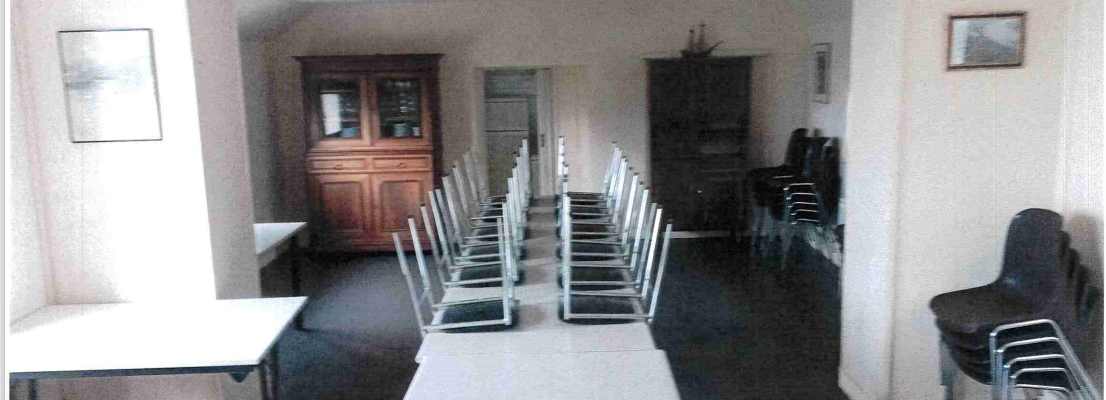 Pièce avec tables, chaises, buffet, et armoire.