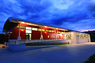 "Immeuble moderne avec éclairage LED, fenêtres, porte en verre et parking".