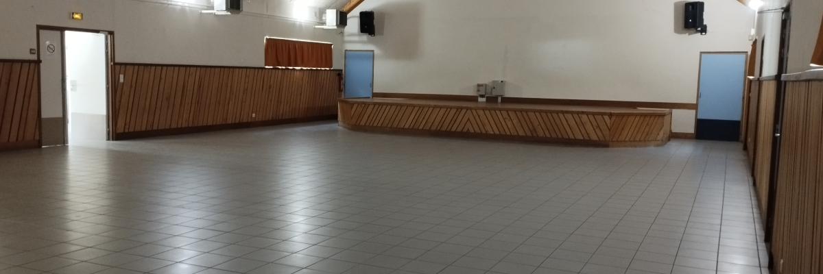 Salle vide avec sol carrelé, distributeur d'eau, et bois mural.