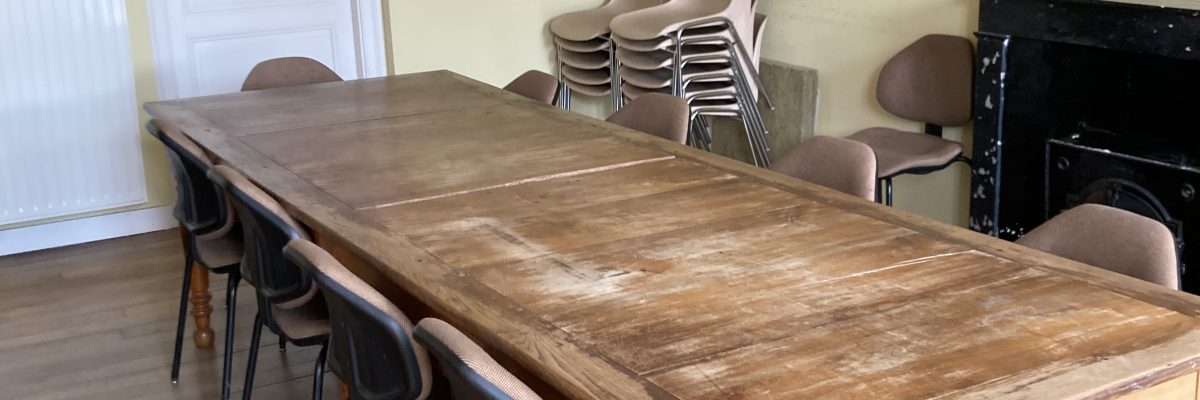 "Salle avec table en bois, chaises, portes et radiateur".