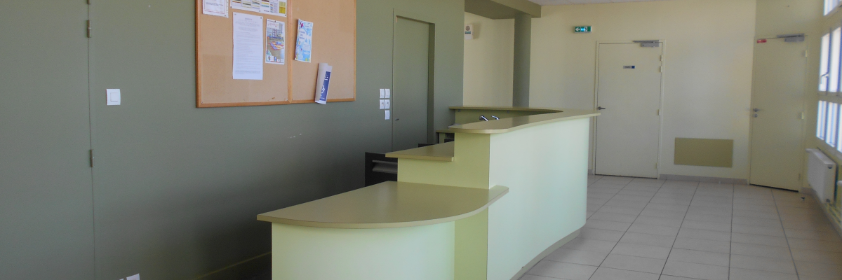 Bureau avec comptoir, panneau d'affichage, portes et carrelage.