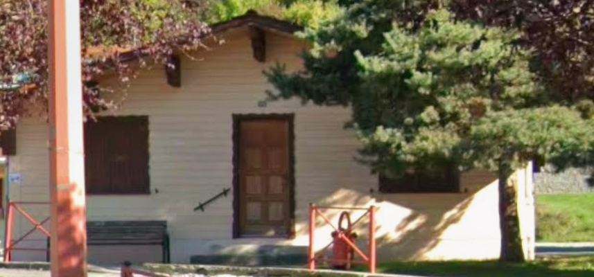 Maison avec porte, fenêtres et entrée partiellement bloquée par un arbre.