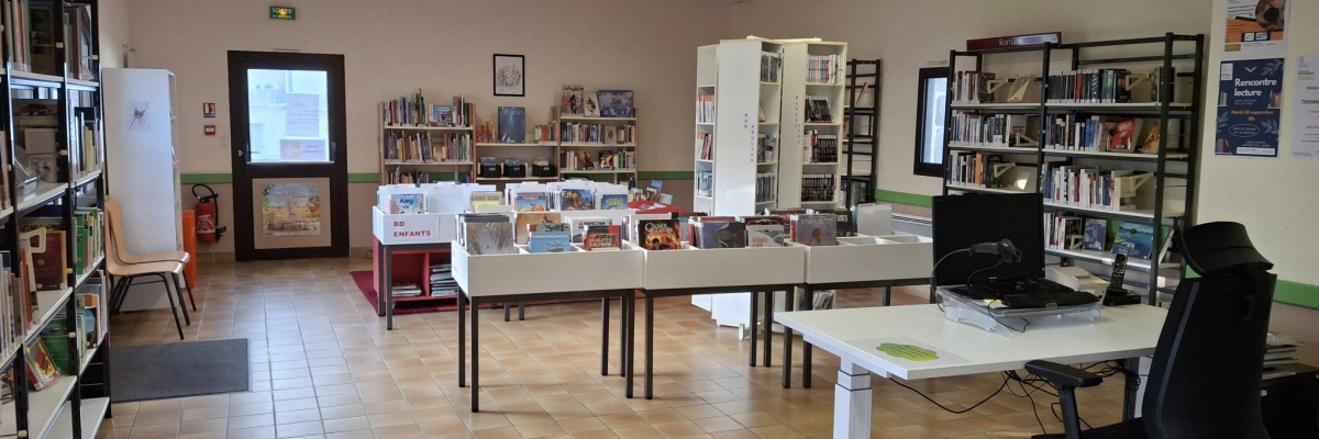 "Bibliothèque avec livres, étagères, ordinateurs, chaises et tables. Éclairage au plafond."