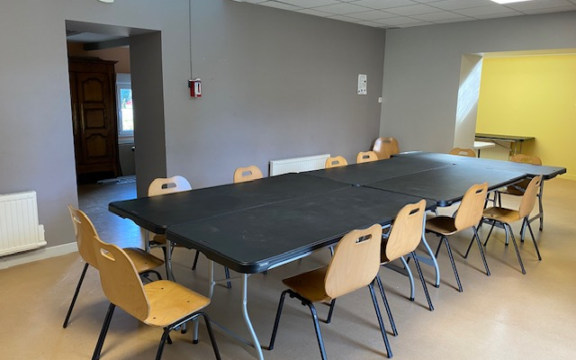 Salle avec table, chaises et radiateur.