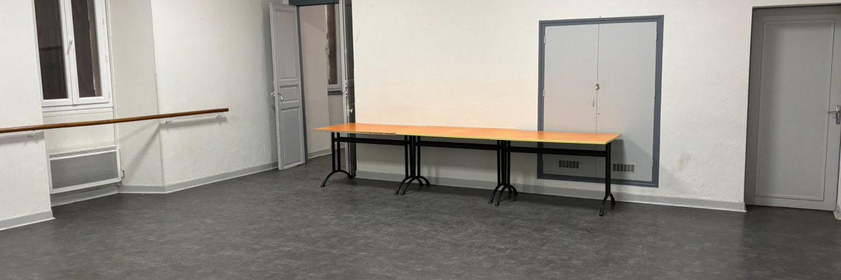 Salle vide avec table, portes et radiateurs.