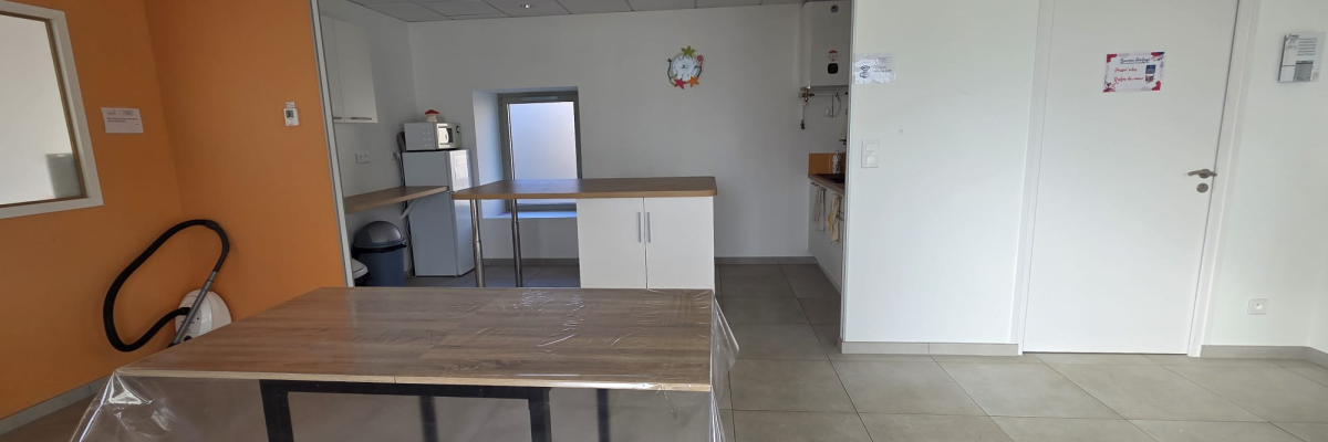 Pièce avec table, chaises, comptoir, porte et interrupteurs.