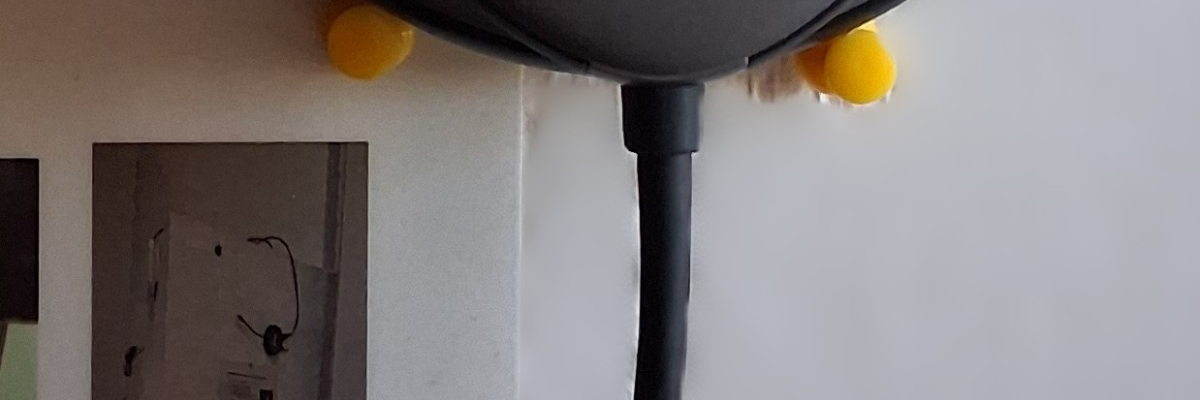 Un boîtier de câble noir avec des connecteurs USB. Deux câbles noirs attachés, un USB-A et un USB-C. Un autocollant jaune avec du texte.