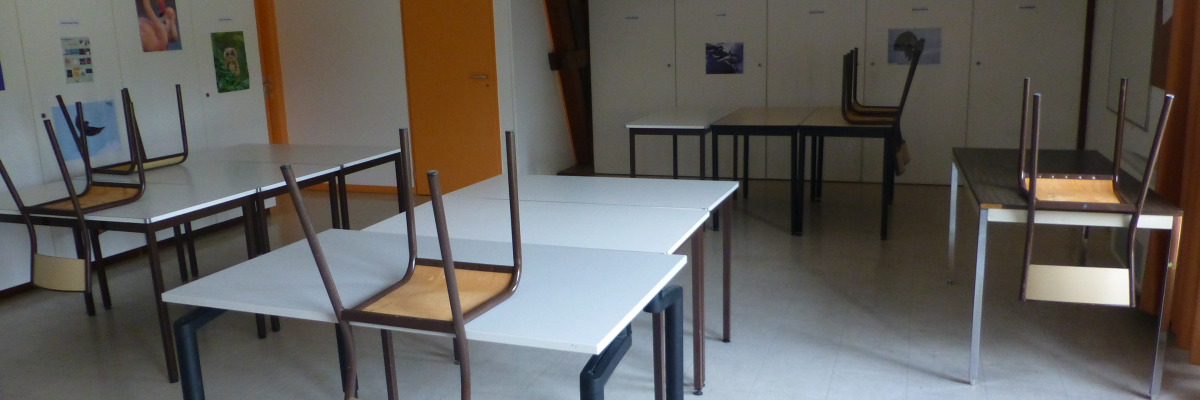 "Salle avec tables, chaises, armoires et porte orange."
