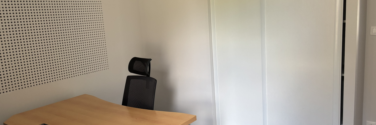 Bureau avec table, chaise, et panneau acoustique.