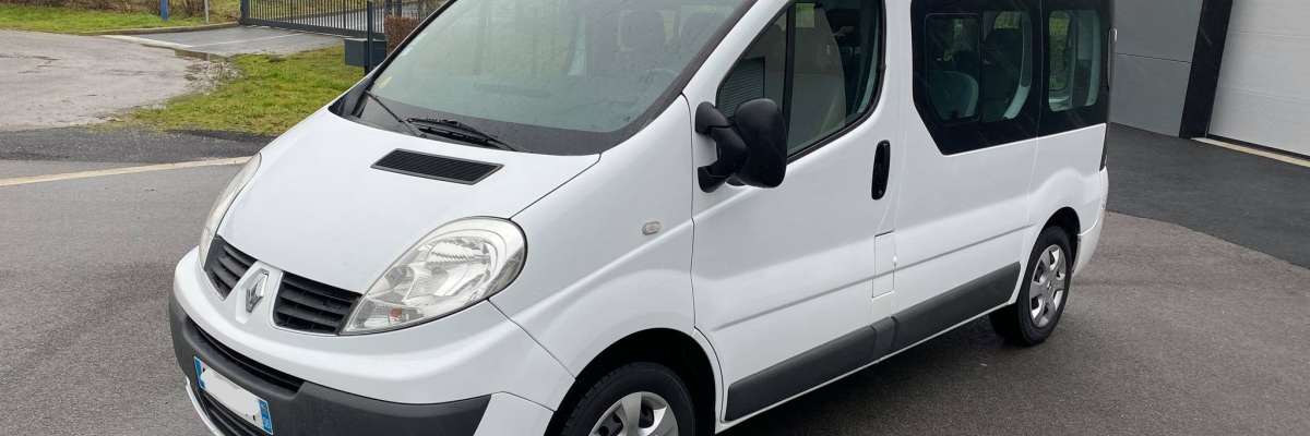 Véhicule blanc stationné devant un bâtiment.