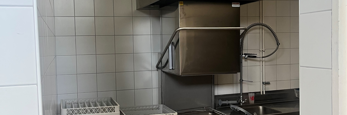 Cuisine avec four, lave-vaisselle, éviers, étagères et armoires.