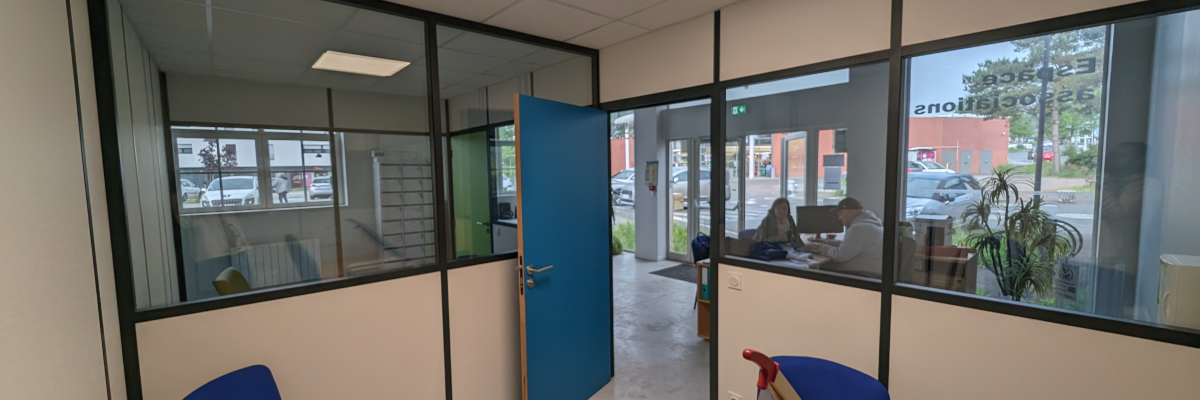 Bureau avec table, chaises, boîte en carton, porte et fenêtres.