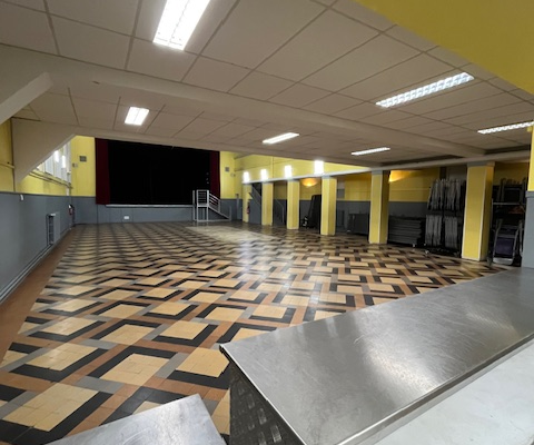 Salle avec sol en carreaux, métal et lumières au plafond.