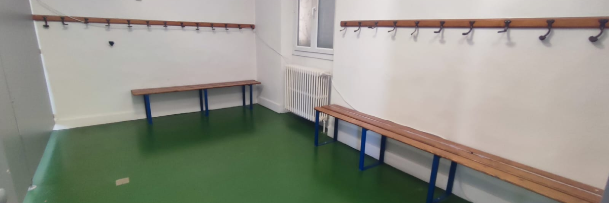 Vestiaire avec bancs et patères.
