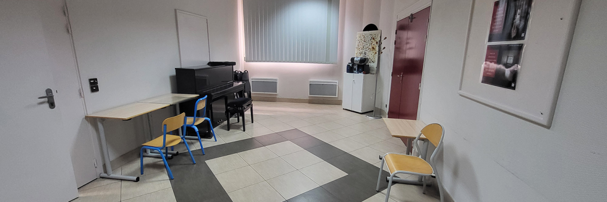 Salle avec piano, tables, chaises, armoire.