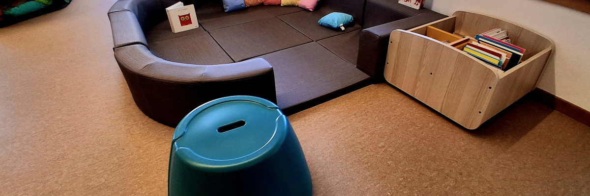 Canapé, coussins, table basse, chaise, pouf, étagère à livres, fenêtres, porte.