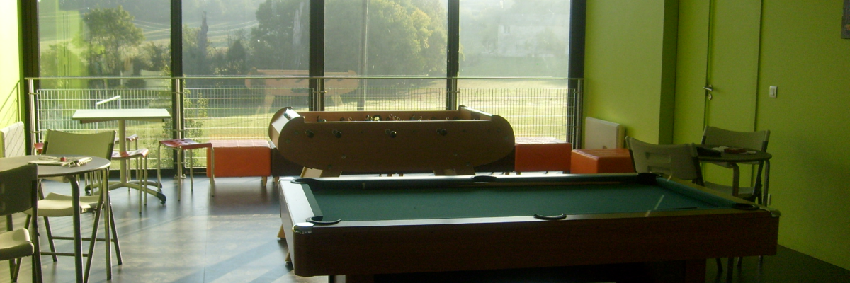 Salle avec billard, tables, chaises, et canapés.