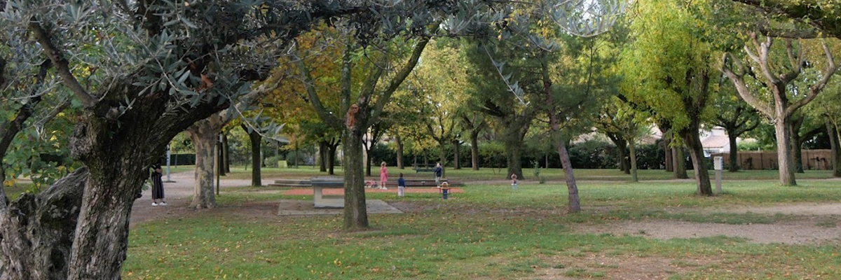 Parc avec arbres, pelouse, sentiers, bancs, aire de jeux et personnes.