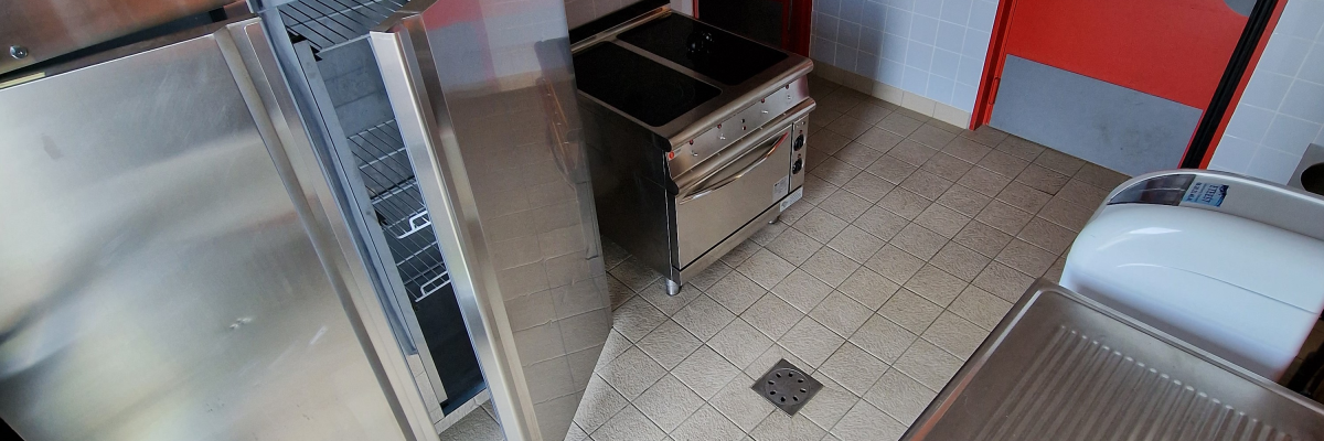 Cuisine avec évier, lave-vaisselle, réfrigérateur, comptoir, et armoire de rangement.