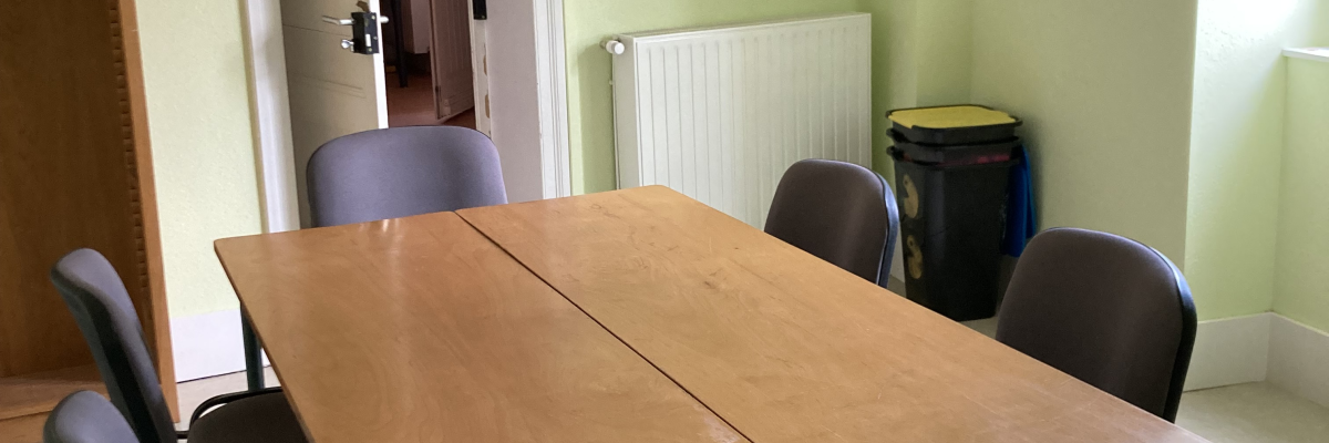 Salle avec table, chaises et radiateur.