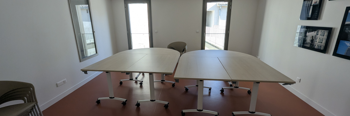 Salle avec tables, chaises, et photos murales.