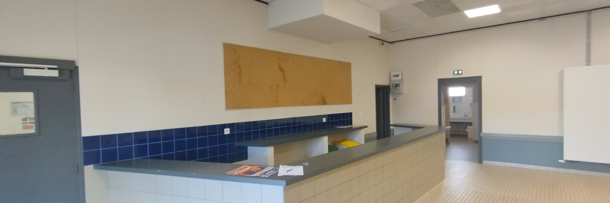 Cuisine avec comptoir, tableau d'affichage, évier, plaques électriques, four, frigo, et lave-vaisselle.