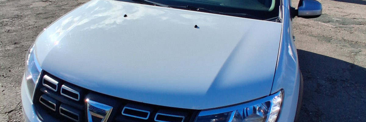 Voiture blanche garée devant un bâtiment.