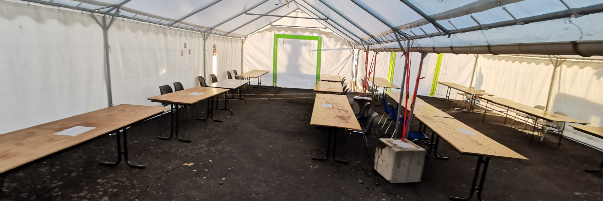 Tente avec tables, chaises, et générateur.