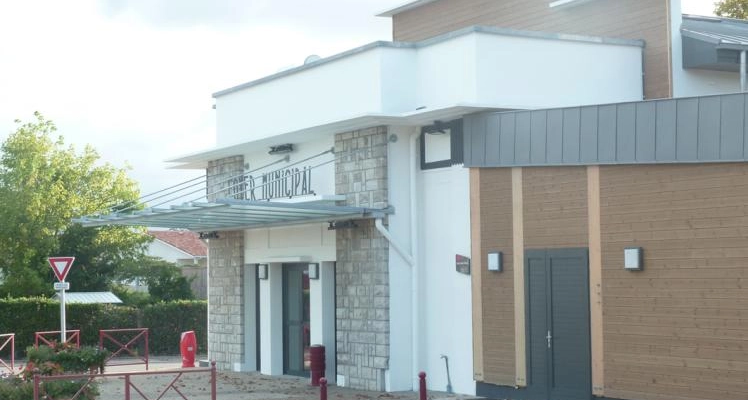 "Bâtiment avec enseigne "Cimetière Municipal", porte, interphone et barrières."