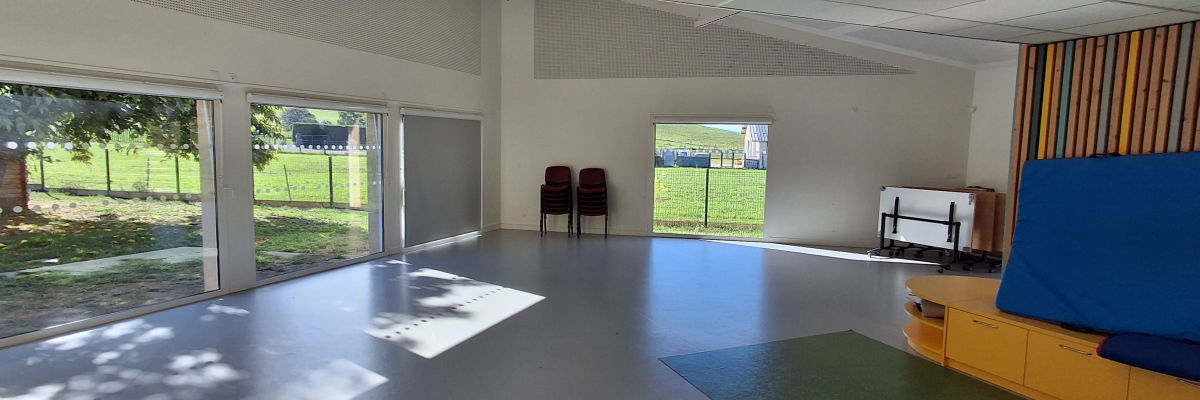 Salle avec table, chaises, canapé, porte et fenêtres.