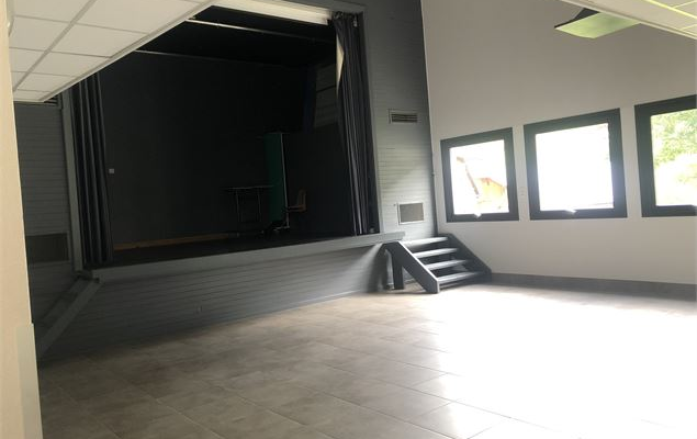 Pièce vide avec escalier, portes et fenêtres.