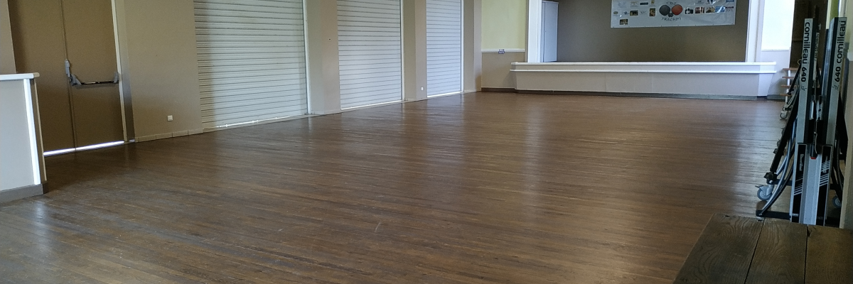 Salle vide avec parois de store, porte, banc et mur d'affichage.