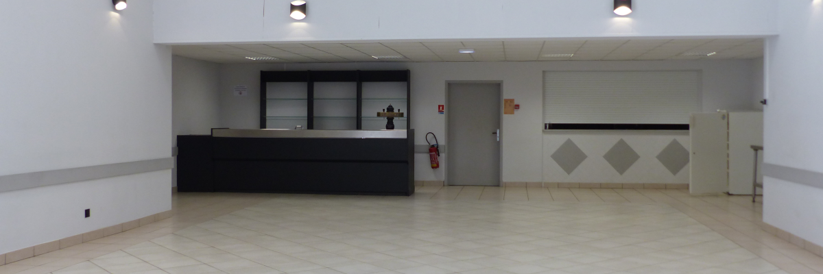 Salle avec comptoir, porte, extincteur, et frigo.