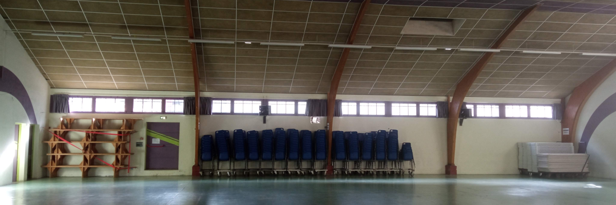 Salle spacieuse avec chaises, étagères et chariot.