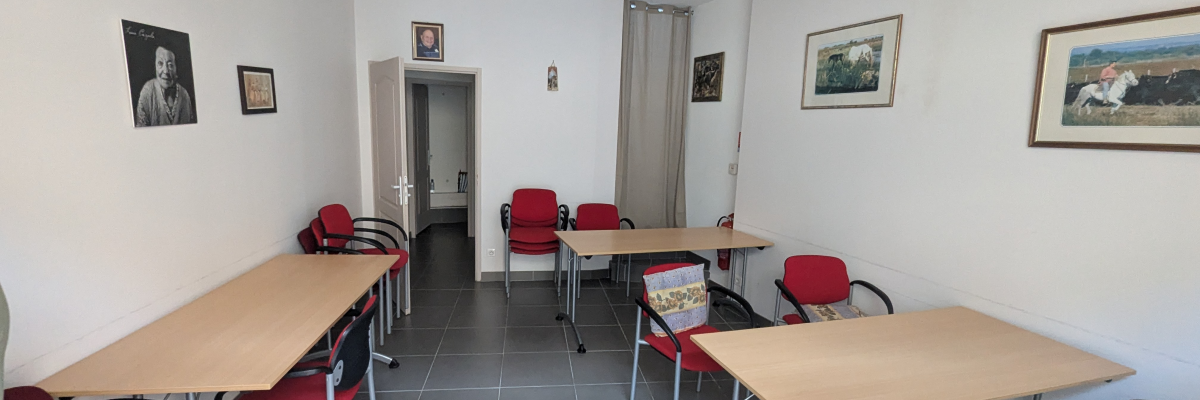 Salle avec tables, chaises, climatiseur, tableaux et lumières.