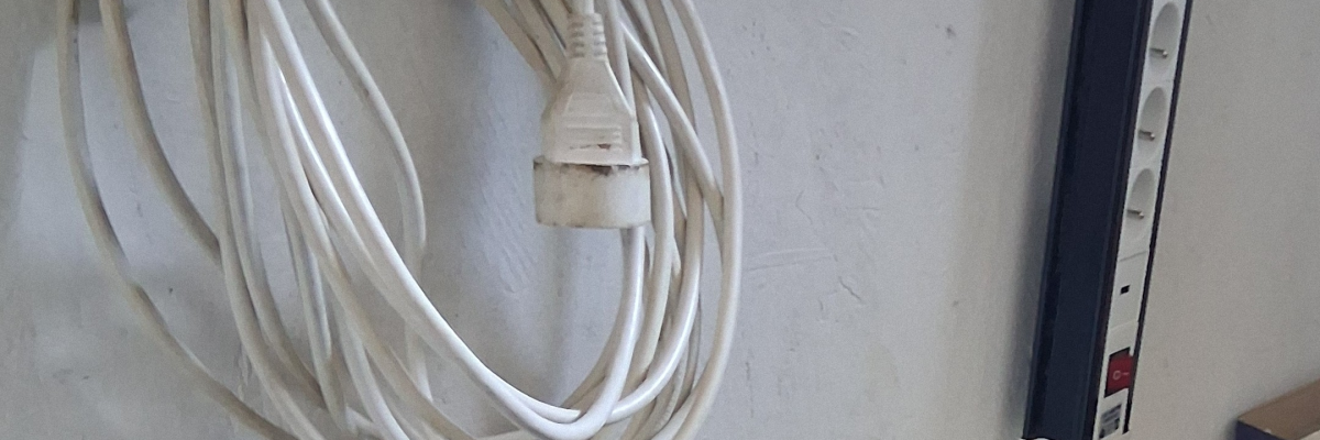 Longs câbles blancs branchés au mur.