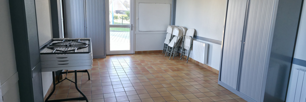 Pièce avec table roulante, porte et classeurs.