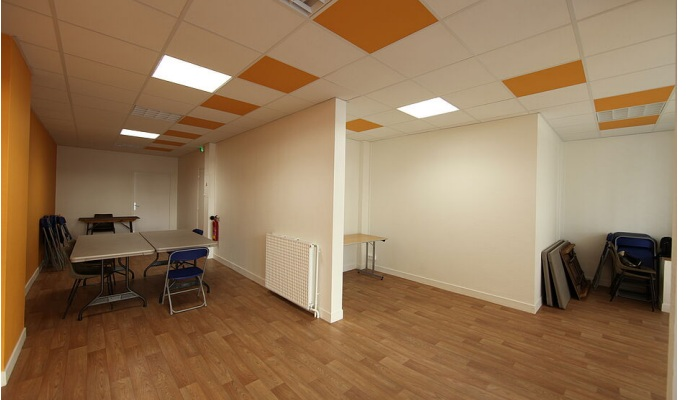 Pièce vide avec table, chaises, radiateur, et étagères.