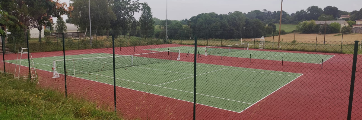 Terrains de tennis avec filet, clôture et éclairage.
