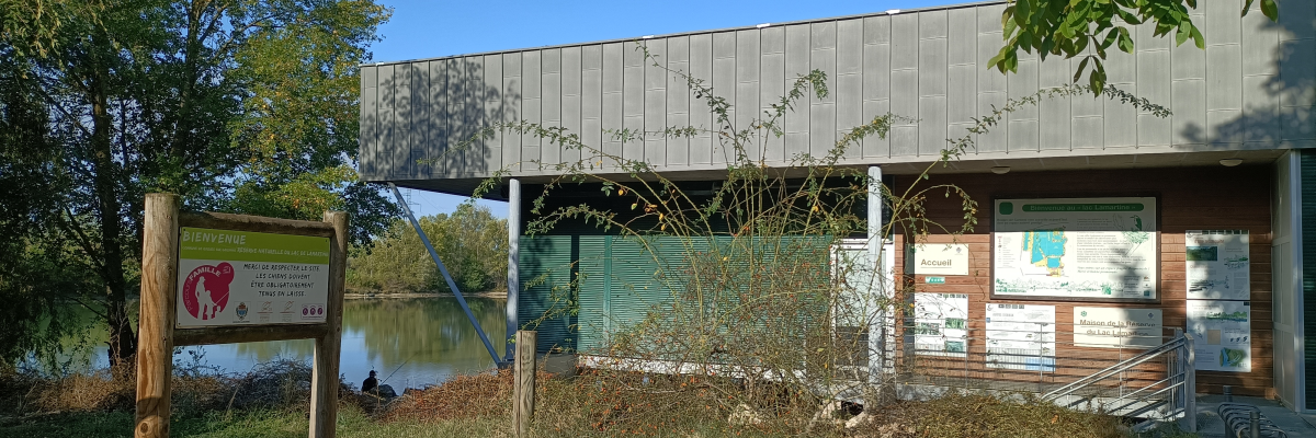 Bâtiment avec panneau, cheminée, porte, fenêtre et vue sur l'eau.