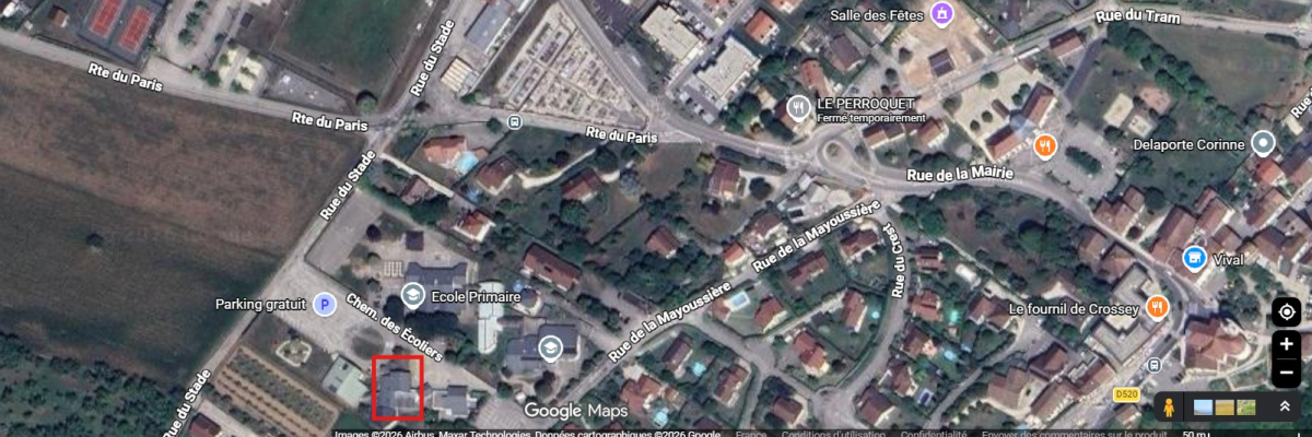 Vue aérienne d'un quartier avec rues, bâtiments, écoles, parkings et commerces.
