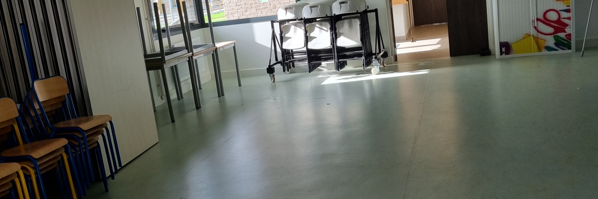 Salle avec tables, chaises, porte, fenêtre, et décorations murales.