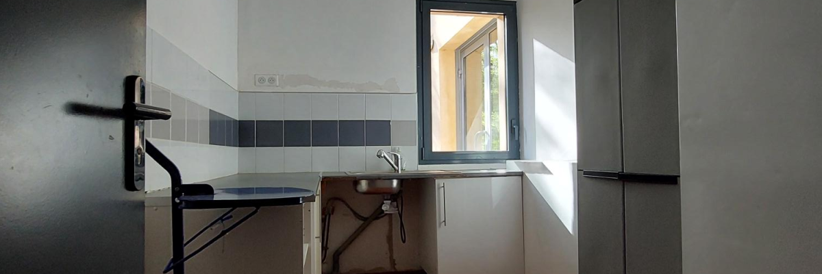 Pièce avec évier, chariot, porte et fenêtre.