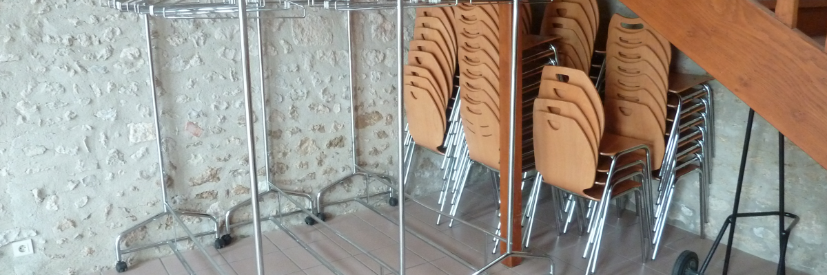 Chariots à plateaux et empilement de chaises près d'un escalier.