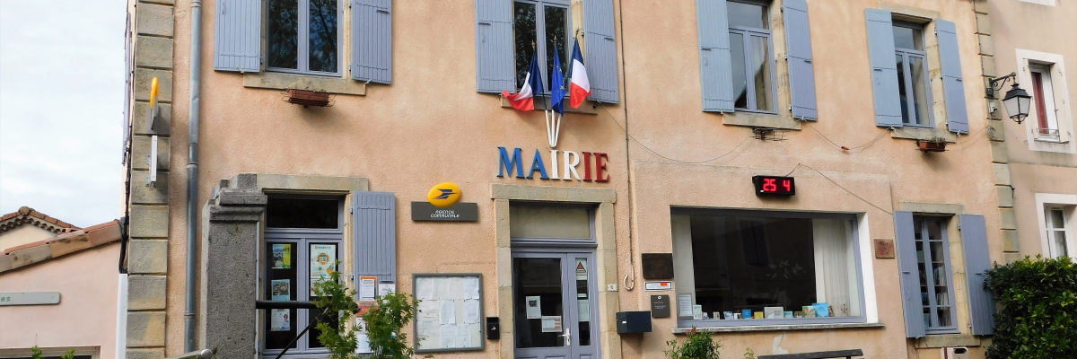 Mairie avec enseigne, drapeaux, poteries, banc, et entrée principale.