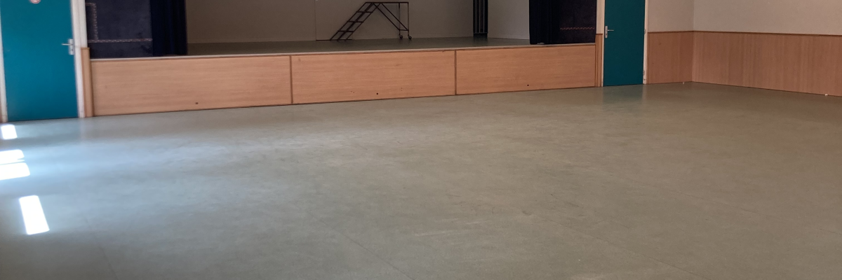 Salle vide avec miroir, bancs, et fenêtres.