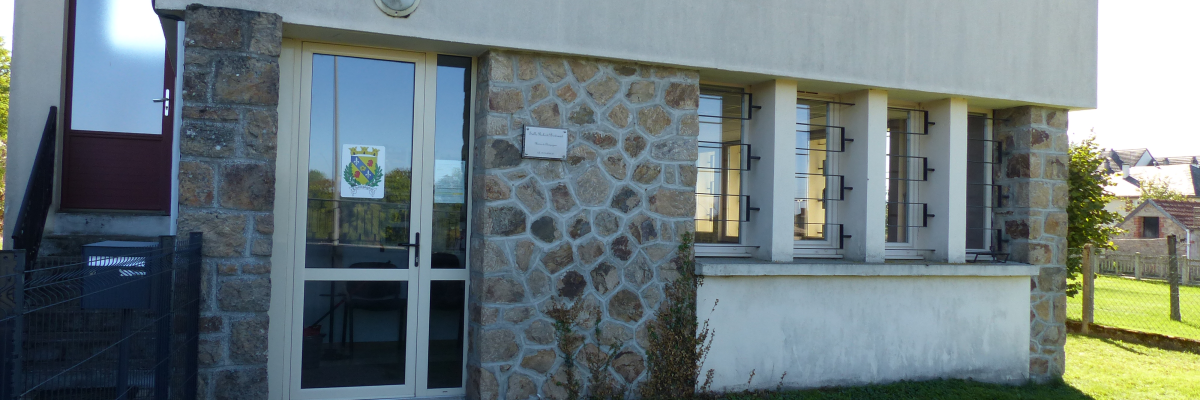 Maison avec porte d'entrée, fenêtres, mur de pierre et pelouse.