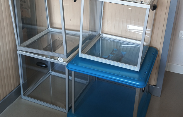 Deux cages en verre avec base bleue.